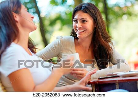 Stock Photo - Women sisters 35 and 40 years taking coffee on a terrace. Donostia. San Sebastian. Gipuzkoa. Basque Country- Spain.. Fotosearch