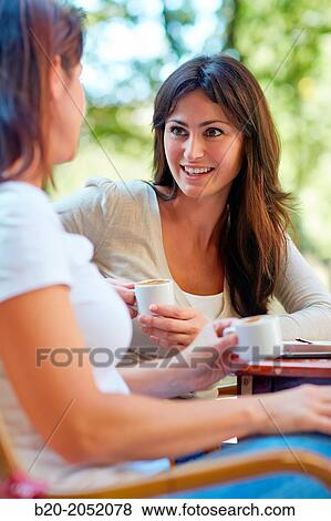 Stock Photo - Women sisters 35 and 40 years taking coffee on a terrace. Donostia. San Sebastian. Gipuzkoa. Basque Country- Spain.. Fotosearch