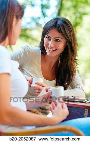 Stock Photo - Women sisters 35 and 40 years taking coffee on a terrace. Donostia. San Sebastian. Gipuzkoa. Basque Country- Spain.. Fotosearch