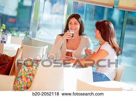 Stock Photo - Women sisters 35 and 40 years taking coffee on a terrace. Donostia. San Sebastian. Gipuzkoa. Basque Country- Spain.. Fotosearch