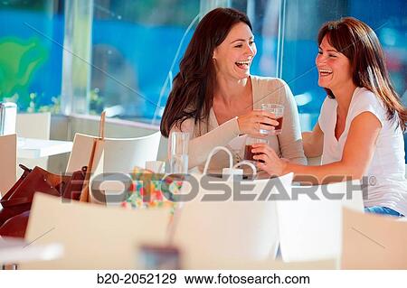 Stock Photo - Women sisters 35 and 40 years taking coffee on a terrace. Donostia. San Sebastian. Gipuzkoa. Basque Country- Spain.. Fotosearch