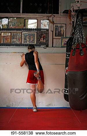 Stock Photo - Women stretching her leg before Thai-Boxing lesson ( Muay Thai ). Bangkok. Thailand. Fotosearch
