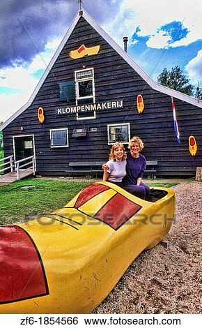 Stock Photograph - Women tourists at Cheese Factory with giabt clog shoe in Volendam Holland. Fotosearch