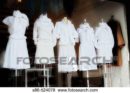 Stock Photo - Women's white summer clothing displayed in a retail store window. Fotosearch
