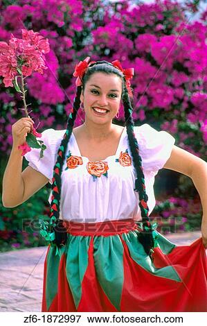 Stock Photo - Wonderful costumed woman dancer with flowers in San Miguel de Allende Mexico tourist town. Fotosearch