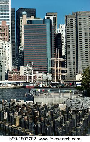 WOOD PILINGS PIER ONE BROOKLYN EAST RIVER TO MANHATTAN SKYLINE NEW YORK CITY USA View Large Photo Image Stock Image - WOOD PILINGS PIER ONE BROOKLYN EAST RIVER TO MANHATTAN SKYLINE NEW YORK CITY USA. Fotosearch