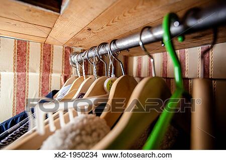 Wooden and one green plastic hanger in a wardrobre View Large Photo Image Picture - Wooden and one green plastic hanger in a wardrobre. Fotosearch