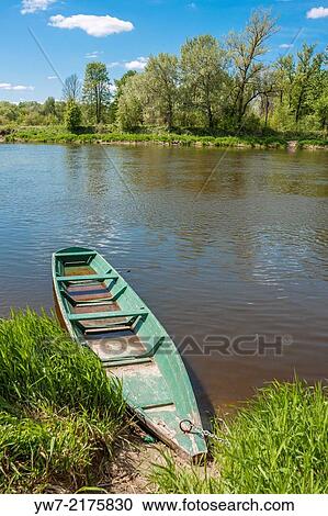 Stock Image - Wooden boat on Bug river in Drohiczyn, Poland.. Fotosearch