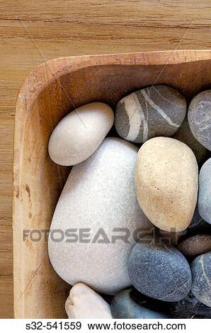 Stock Photo - Wooden bowl filled with stones. Fotosearch