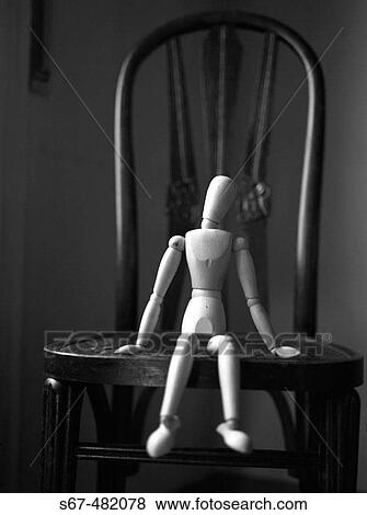 Wooden figure sitting on a chair in a fragility attitude. View Large Photo Image Stock Photo - Wooden figure sitting on a chair in a fragility attitude.. Fotosearch