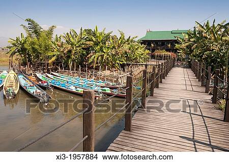 Picture - Wooden path leading to the Inthar Heritage House, Inpawkhon Village, Inle Lake, Shan State, Myanmar, (Burma).. Fotosearch