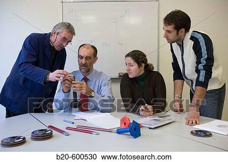 Stock Image - Work team meeting. Watching chisels. Manual tool.. Fotosearch