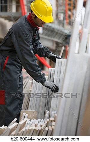 Picture - Worker and construction materials. Building construction.. Fotosearch