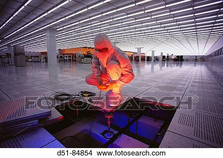 Picture - Worker checking floor wiring in semiconductor plant. USA. Fotosearch