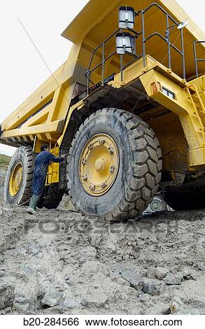 Worker cleaning dumper-truck to carry marl from quarry to cement plant View Large Photo Image Stock Photograph - Worker cleaning dumper-truck to carry marl from quarry to cement plant. Fotosearch