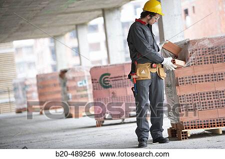 Worker picking bricks. Housing construction, apartments. San Sebastian, Gipuzkoa, Euskadi. Spain. View Large Photo Image Stock Photograph - Worker picking bricks. Housing construction, apartments. San Sebastian, Gipuzkoa, Euskadi. Spain.. Fotosearch