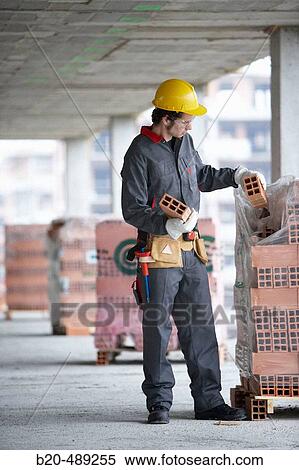 Worker picking bricks. Housing construction, apartments. San Sebastian, Gipuzkoa, Euskadi. Spain. View Large Photo Image Stock Photography - Worker picking bricks. Housing construction, apartments. San Sebastian, Gipuzkoa, Euskadi. Spain.. Fotosearch