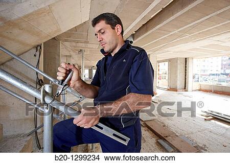Worker using pliers, new homes under construction, construction site View Large Photo Image Picture - Worker using pliers, new homes under construction, construction site. Fotosearch