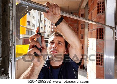 Worker using screwdriver, assembling window frame, new homes under construction, construction site View Large Photo Image Stock Image - Worker using screwdriver, assembling window frame, new homes under construction, construction site. Fotosearch