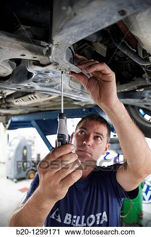 Worker using screwdriver in car repair shop View Large Photo Image Stock Image - Worker using screwdriver in car repair shop. Fotosearch