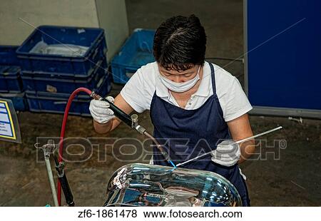 Stock Photo - Worker welding in Pewter Factory called Royal Selangor in Kuala Lumpur Malaysia Asia. Fotosearch
