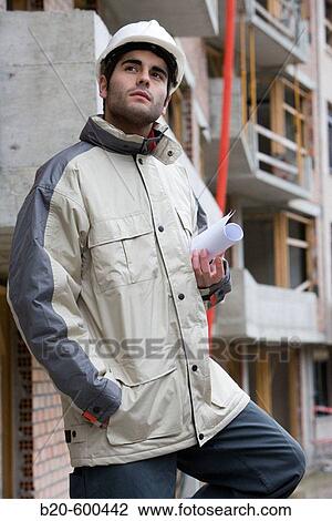 Stock Image - Worker with blueprints. Building construction.. Fotosearch