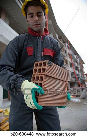 Stock Photo - Worker with bricks. Building construction.. Fotosearch