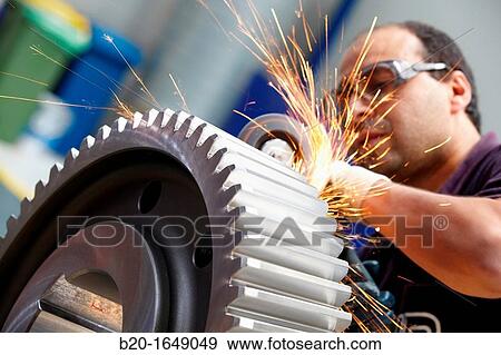 Stock Photo - Worker with grinder finish by piece, production of steel gears, cogwheel, mechanical industry, gearbox mill, Gipuzkoa, Basque Country, Spain. Fotosearch