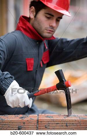 Stock Photo - Worker with pickaxe, building construction.. Fotosearch