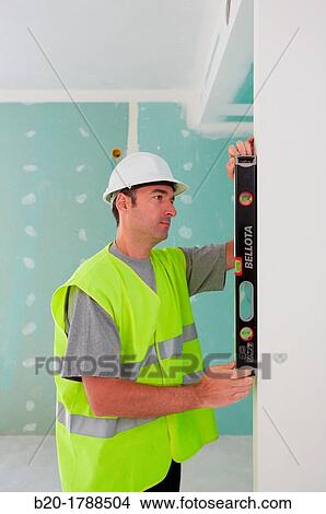 Worker with protective equipment, PPE, Leveling plasterboard panels, housing construction, level, Basque Country, Spain View Large Photo Image Picture - Worker with protective equipment, PPE, Leveling plasterboard panels, housing construction, level, Basque Country, Spain. Fotosearch