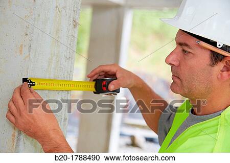 Stock Image - Worker with protective equipment, PPE, Taking measures in concrete beam, retractable tape, housing construction, Basque Country, Spain. Fotosearch
