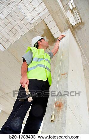 Worker with protective equipment, PPE, Checking and aligning vertical sections in concrete walls, housing construction, Plumb line, Basque Country, Spain View Large Photo Image Stock Image - Worker with protective equipment, PPE, Checking and aligning vertical sections in concrete walls, housing construction, Plumb line, Basque Country, Spain. Fotosearch