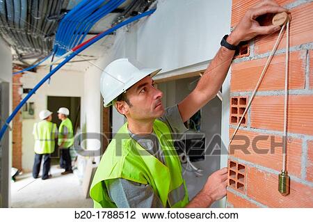 Worker with protective equipment, PPE, Checking and aligning vertical sections in brick wall, housing construction, Plumb line, Basque Country, Spain View Large Photo Image Stock Image - Worker with protective equipment, PPE, Checking and aligning vertical sections in brick wall, housing construction, Plumb line, Basque Country, Spain. Fotosearch