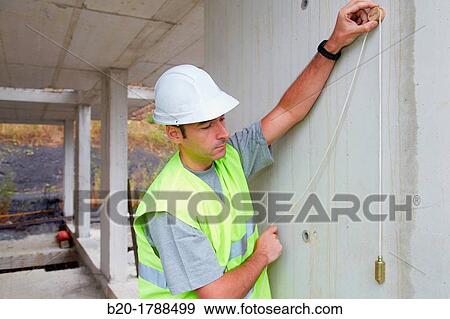 Worker with protective equipment, PPE, Checking and aligning vertical sections in concrete walls, housing construction, Plumb line, Basque Country, Spain View Large Photo Image Stock Photo - Worker with protective equipment, PPE, Checking and aligning vertical sections in concrete walls, housing construction, Plumb line, Basque Country, Spain. Fotosearch