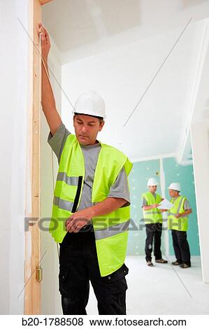 Worker with protective equipment, PPE, Checking and aligning vertical sections in preframe door, housing construction, Plumb line, Basque Country, Spain View Large Photo Image Stock Photo - Worker with protective equipment, PPE, Checking and aligning vertical sections in preframe door, housing construction, Plumb line, Basque Country, Spain. Fotosearch