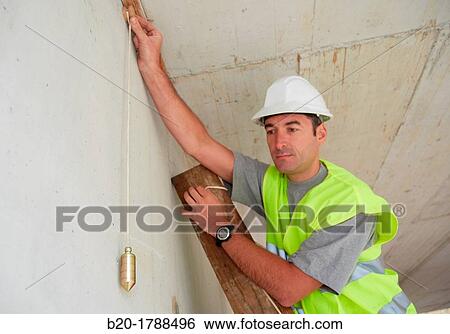 Worker with protective equipment, PPE, Checking and aligning vertical sections in concrete walls, housing construction, Plumb line, Basque Country, Spain View Large Photo Image Stock Photograph - Worker with protective equipment, PPE, Checking and aligning vertical sections in concrete walls, housing construction, Plumb line, Basque Country, Spain. Fotosearch