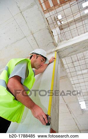 Worker with protective equipment, PPE, Taking measures in concrete beam, retractable tape, housing construction, Basque Country, Spain View Large Photo Image Stock Photography - Worker with protective equipment, PPE, Taking measures in concrete beam, retractable tape, housing construction, Basque Country, Spain. Fotosearch