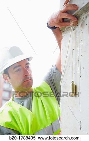 Worker with protective equipment, PPE, Checking and aligning vertical sections in concrete walls, housing construction, Plumb line, Basque Country, Spain View Large Photo Image Stock Photography - Worker with protective equipment, PPE, Checking and aligning vertical sections in concrete walls, housing construction, Plumb line, Basque Country, Spain. Fotosearch