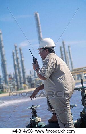 Worker with radio in hand at oil refinery View Large Photo Image Stock Photograph - Worker with radio in hand at oil refinery. Fotosearch