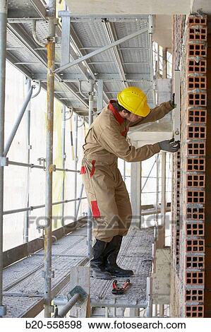 Worker with spirit level on scaffold, housing construction. Guipuzcoa, Euskadi, Spain View Large Photo Image Stock Photo - Worker with spirit level on scaffold, housing construction. Guipuzcoa, Euskadi, Spain. Fotosearch