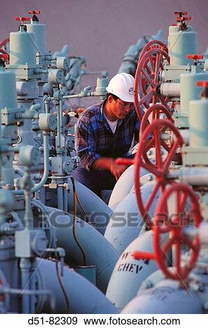 Worker with valves and gauges, gasoline pipeline network View Large Photo Image Stock Photo - Worker with valves and gauges, gasoline pipeline network. Fotosearch