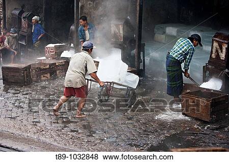 Stock Photo - Workers crashing ice in the fish market. Fotosearch
