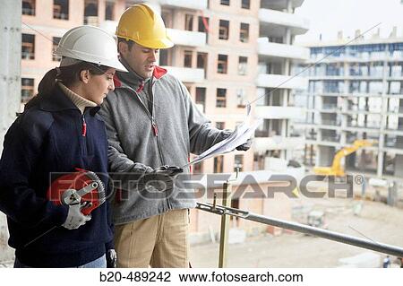 Workers with blueprints and measuring tape. Housing construction, apartments. San Sebastian, Gipuzkoa, Euskadi. Spain. View Large Photo Image Stock Image - Workers with blueprints and measuring tape. Housing construction, apartments. San Sebastian, Gipuzkoa, Euskadi. Spain.. Fotosearch