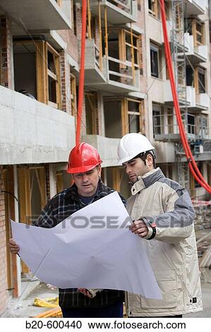 Stock Image - Workers with blueprints. Building construction.. Fotosearch