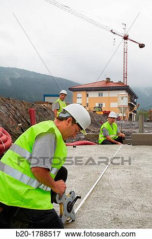 Workers with protective equipment, PPE, Taking measures in urbanization, Outside, Housing construction, Measuring tape, Basque Country, Spain View Large Photo Image Stock Photo - Workers with protective equipment, PPE, Taking measures in urbanization, Outside, Housing construction, Measuring tape, Basque Country, Spain. Fotosearch