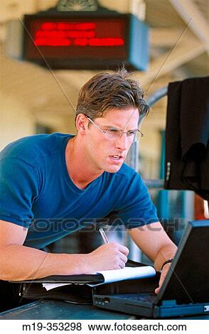 working on a computer in a train station View Large Photo Image Stock Photo - working on a computer in a train station. Fotosearch
