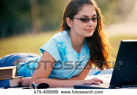 Working on her laptop outdoors View Large Photo Image Stock Photo - Working on her laptop outdoors. Fotosearch