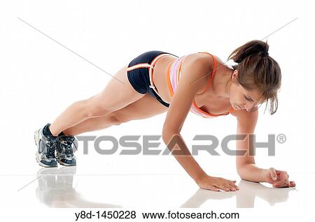 Stock Photo - Working out - Woman doing fitness exercise on white floor. Fotosearch