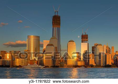 Stock Image - World Financial Center, moon rises amidst the new buildings under construction in the World Trade Center complex, including the Freedom Tower One World Trade Center, in New York City. Fotosearch