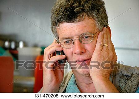 Worried surprised Man working on Cell Phone with glasses View Large Photo Image Stock Photo - Worried surprised Man working on Cell Phone with glasses. Fotosearch